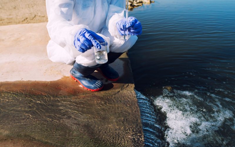 unrecognizable-ecologist-standing-where-sewage-waste-water-meets-river-taking-samples-determine-level-contamination-pollution_342744-950